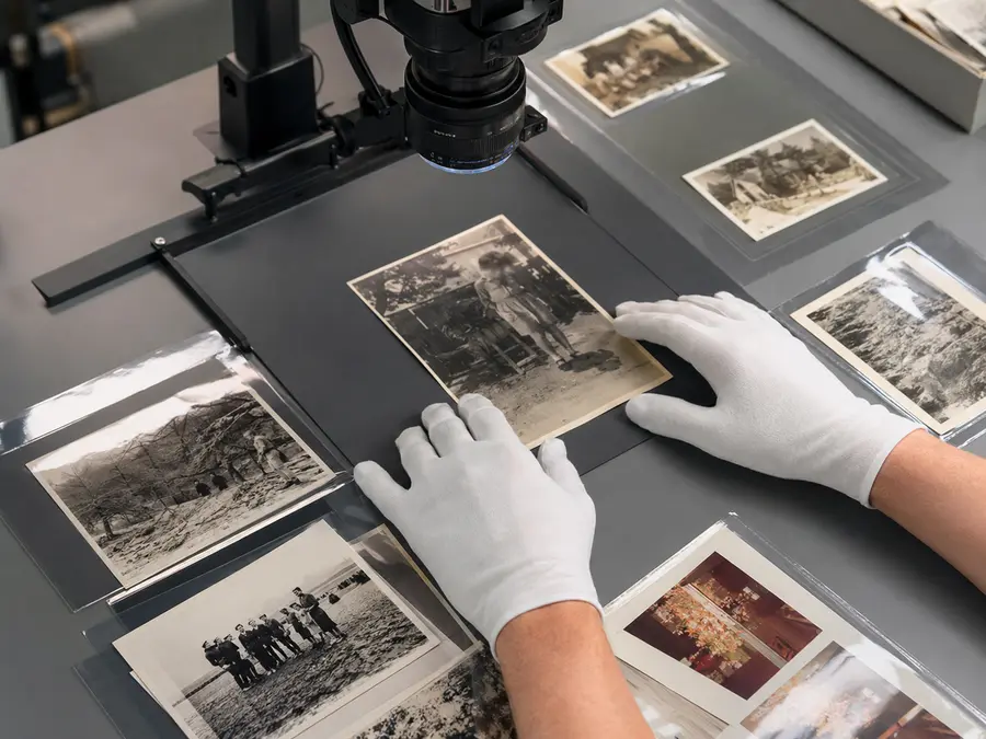 Losse historische fotoafdrukken onder een archiefcamera